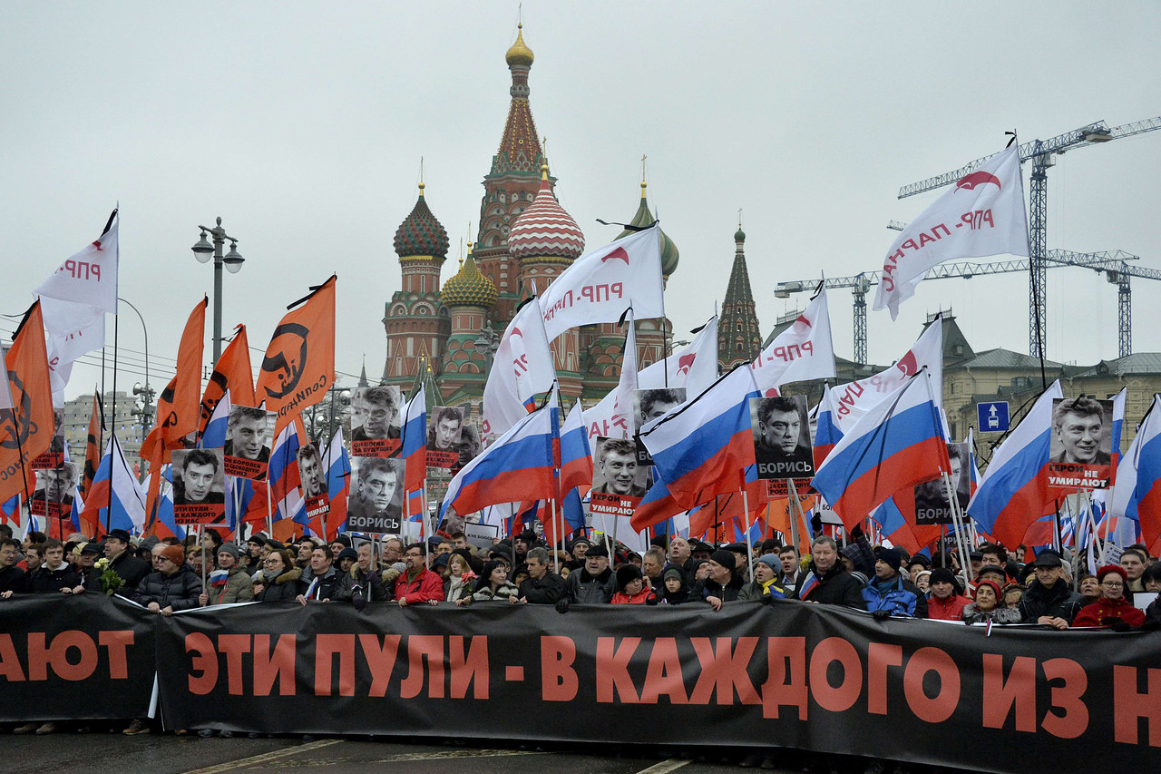 Die Unterstützerinnen und Unterstützer der russischen Opposition tragen ein Transparent, auf dem zu lesen ist: „Diese Kugeln in jedem von uns“, während eines Trauermarsches für den ermordeten Kreml-Kritiker Boris Nemzow im Zentrum Moskaus am 1. März 2015. - FOTO: AGENCE FRANCE-PRESSE/GETTY IMAGES