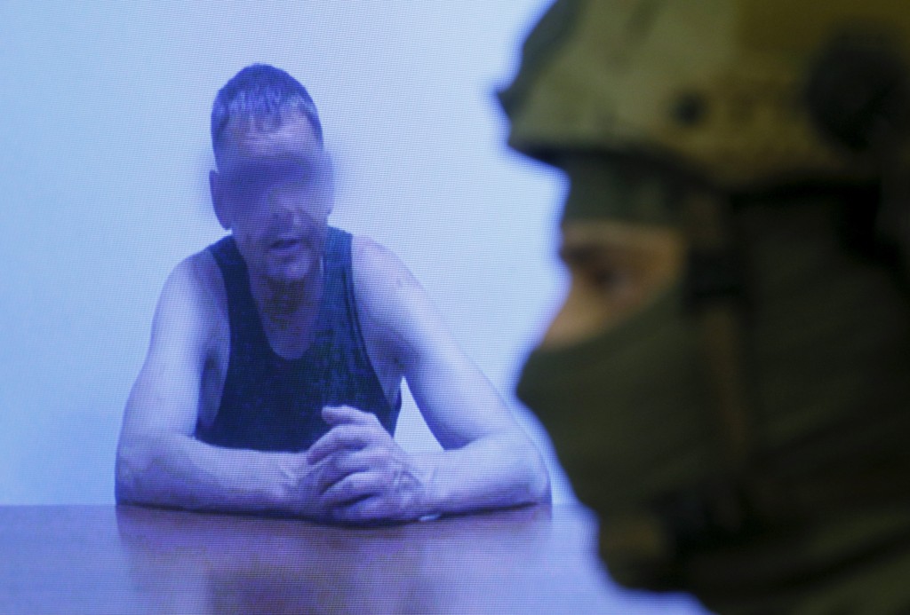 Ein Offizier des ukrainischen Geheimdienstes SBU steht während eines Briefings am 29. Juli neben einem Monitor, in dem, so der SBU, ein russischer Major zu sehen ist, der von ukrainischen Soldaten gefangengenommen wurde. - Foto: REUTERS/Valentyn Ogirenko